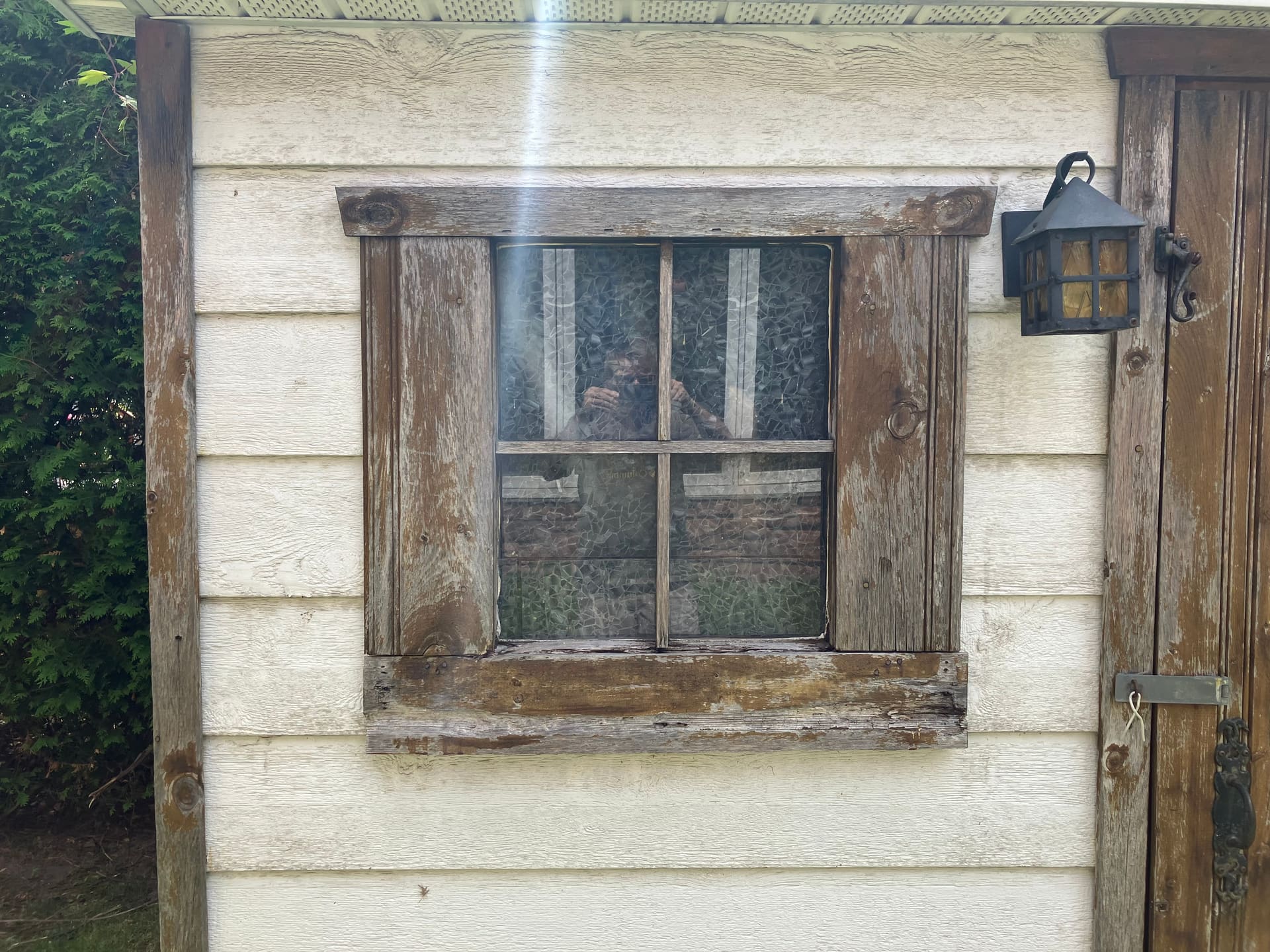 Fenêtre de cabanon avant les travaux, bois gris et fendu