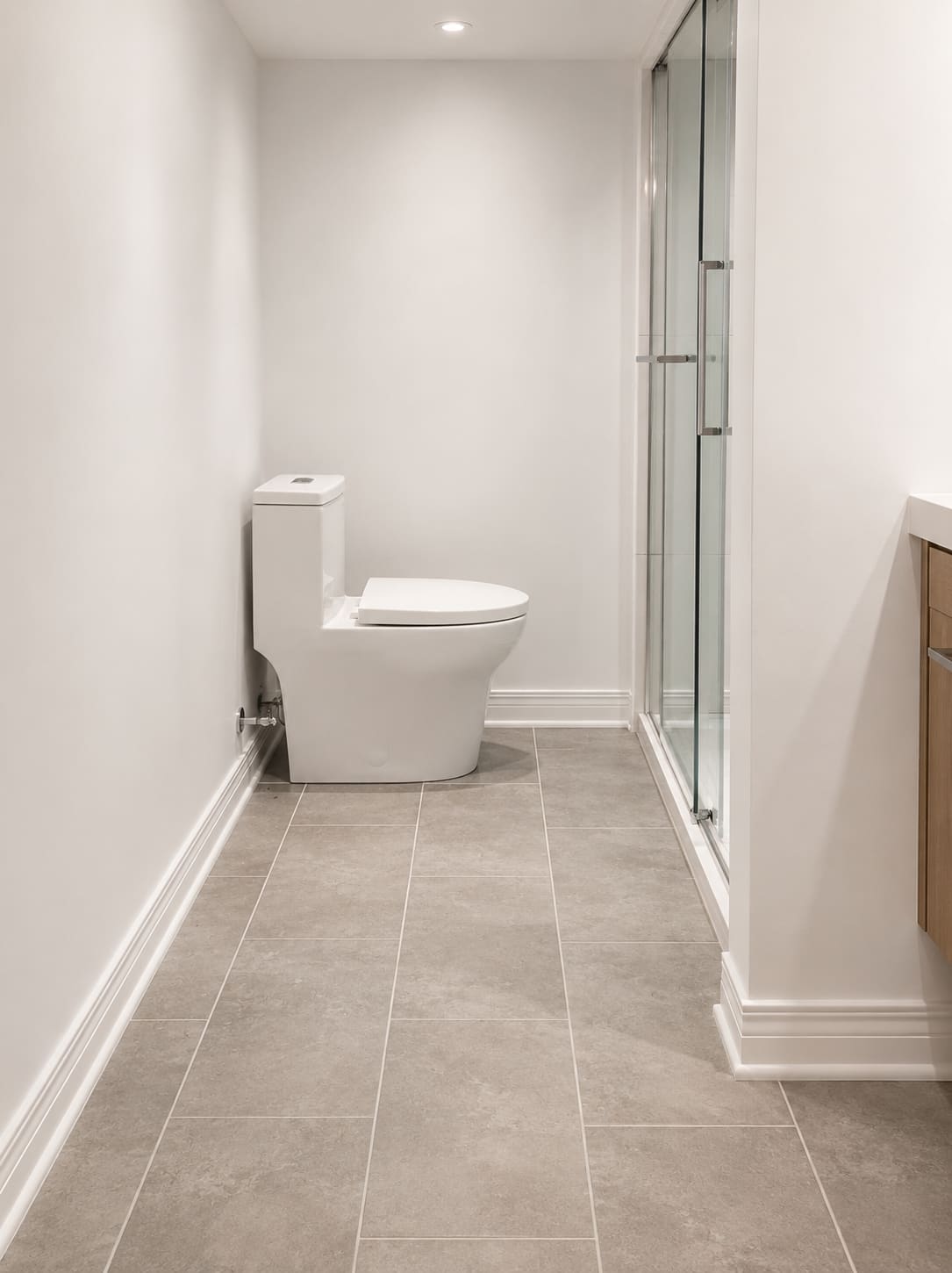 Salle de bain terminée, plancher de céramique grise et douche vitrée